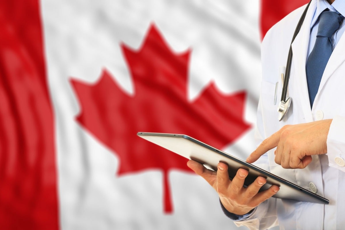 doctor working with tablet and canada flag