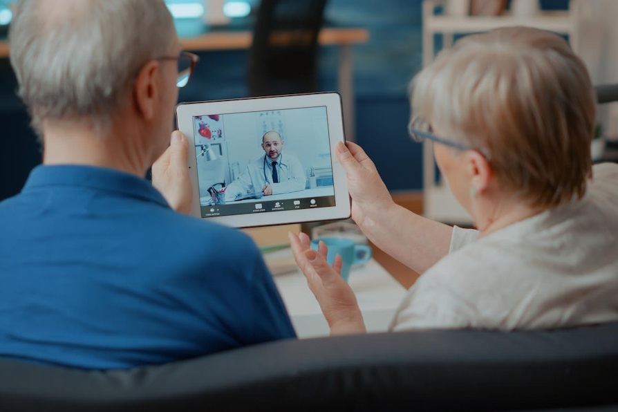 senior couple having online video conference with a doctor